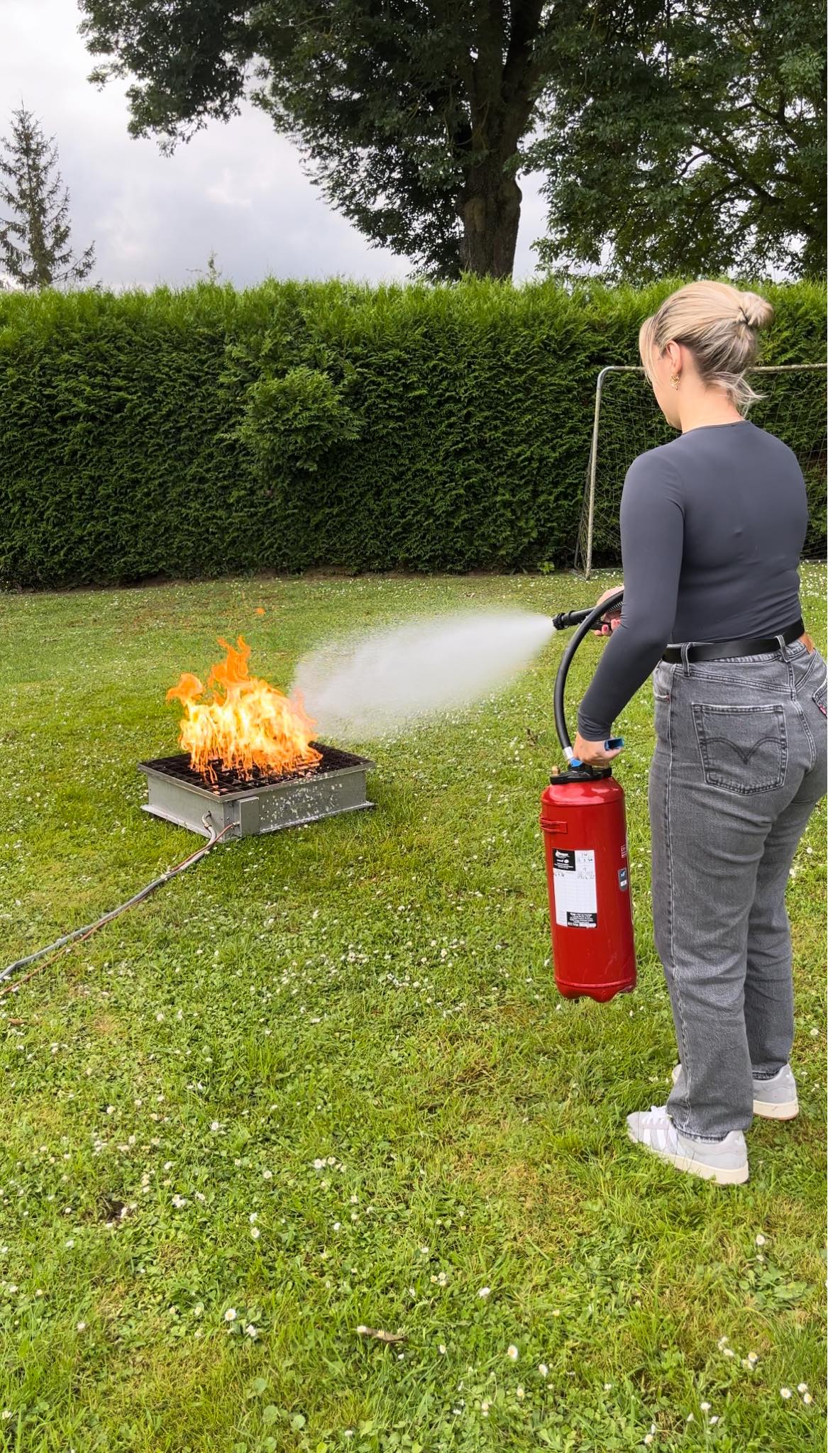 En formation manipulation extincteur, apprentissage de l'usage d'un extinction face à un feu.